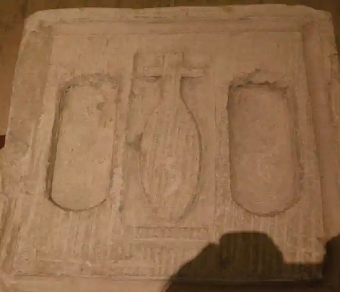 An altar with a symbol of Nefer, a cross on top of an elongated circle, in the middle of two holes